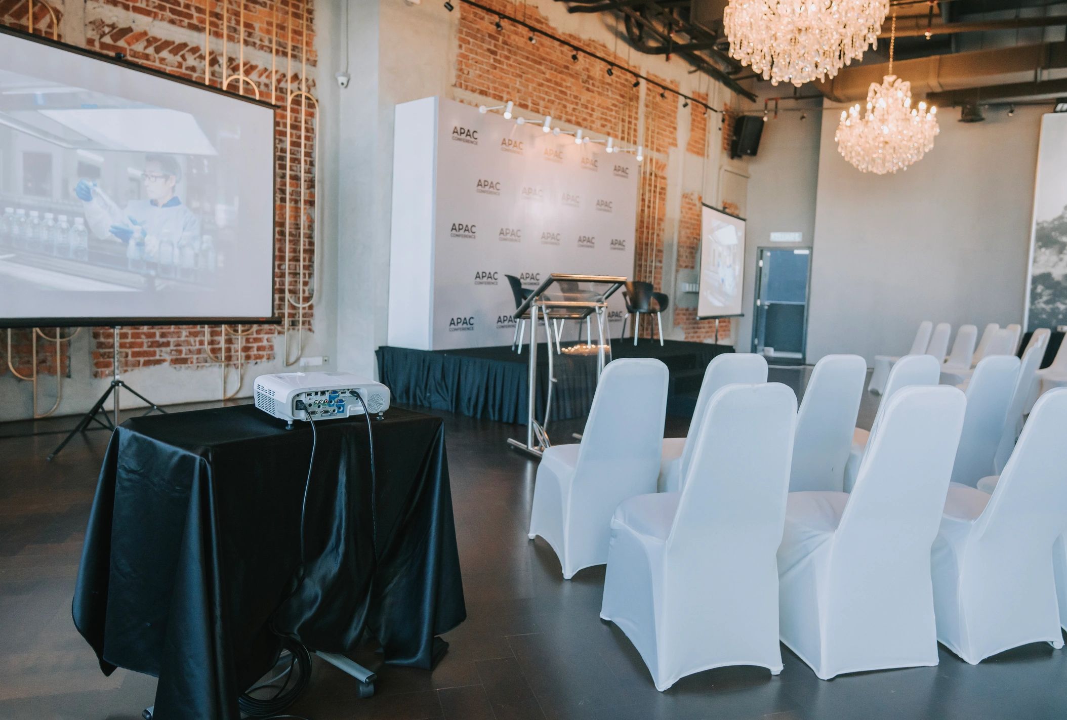 Conference style event setup with screen and audio equipment