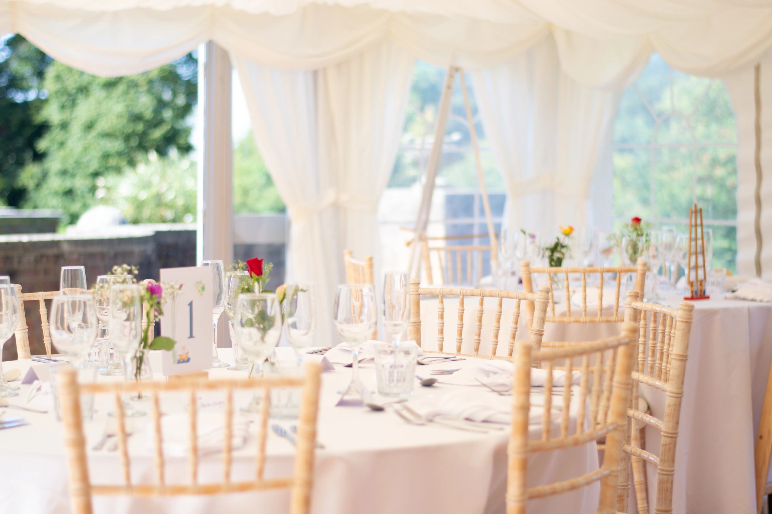Wedding reception table and chair setup inside a marquee